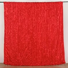 a red curtain hanging on the side of a wall