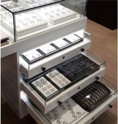 a display case filled with lots of different types of jewelry on top of a wooden floor