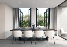 a dining room table surrounded by white chairs