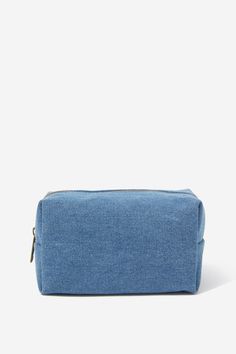 a blue denim pouch bag on a white background, with the zipper open to reveal it's contents