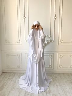 Elegant muslim suit made by soft white color silk. The costume consists of 2 parts of a skirt and a himar, a waist skirt has an elastic band, a lace trimmed with lace, high cuffs with beautiful buttons. On the photo umbrella style skirt, but at variations we also add cheaper variants a flared skirt.We can make different colors. If you want see examples of fabric colors please connect with me!The our goal is to make your image modest, elegant and stylish!Standard skirt length 105 cm, if  you need Dress Nikah, Hijab Stile, Baju Kahwin, Nikah Outfit, Bridal Hijab, Fashion Umbrella, Islamic Dress, Mode Abaya, Muslim Fashion Dress