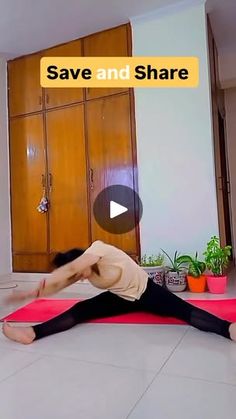 a woman is doing yoga on a mat in the middle of a room with wooden cabinets