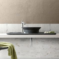 a bathroom sink sitting under a faucet next to a towel on top of a counter