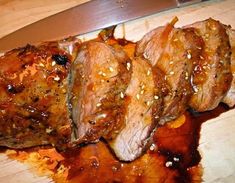 some meat is sitting on a cutting board with a knife in the middle of it