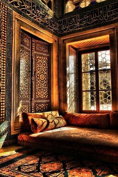 a couch sitting in front of a window next to a rug