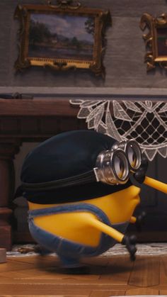 a minion with a hat and goggles on his head is in front of a fireplace