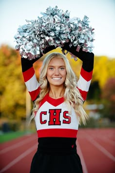 a cheerleader is holding her pom - poms in front of her head