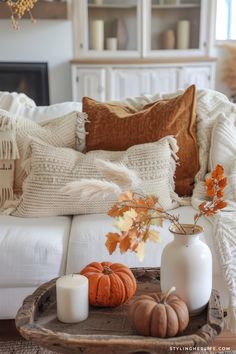 a living room filled with white furniture and fall decorations