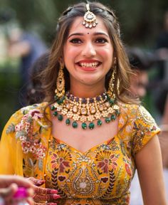 a woman in a yellow dress with jewelry on her head