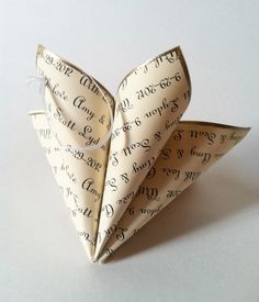 an origami paper folded in the shape of a heart with writing on it