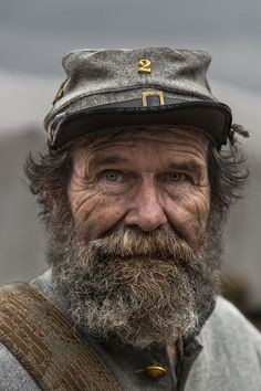 an old man with a beard wearing a hat