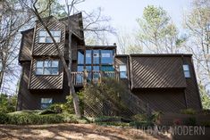 a large brown building surrounded by trees and bushes