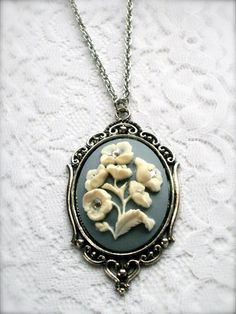 Victorian Floral Blue and White Cameo Necklace with Swarovski Crystals, Floral Design cameo, Romantic Victorian Jewelry, Bouquet Cameo Necklace, Gift for Her This rich, charming Cameo necklace honor timeless charm with a Victorian romance flair. The floral design cameo is set in an ornate antiqued silver plated Victorian style Filigree Setting, adorned with Swarovski crystal for more delightful effect. The Rose is shown in White on a beautiful Pastel Blue background. Hung on a matching silver chain, ready to wear immediately or give as a gift. Cain measures 32" long. This Large Cameo Pendant in total measures approx. 2.5" long. All of my items are carefully and beautifully wrapped  Please visit our shop at https://www.etsy.com/shop/LadyAgathaBoutique Thank you for visiting Lady Agatha Bout Luxury Cameo Necklace For Formal Occasions, Elegant Cameo Necklace For Wedding, Victorian Cameo Pendant Jewelry, Blue Cameo Necklace For Wedding, Vintage Cameo Jewelry, Jewelry Bouquet, Victorian Oval Cameo Pendant Necklace, Victorian Cameo Silver Necklace, Pastel Blue Background