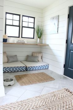 a dog bed in the corner of a room next to a blue door and window