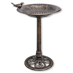 a metal bird bath sitting on top of a table