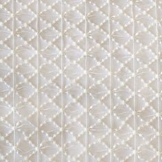 an upholstered quilted fabric with white stitchs and diamond shapes on it