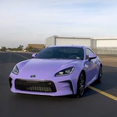 a purple sports car driving down the road