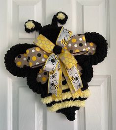 a mickey mouse door hanger with yellow and black polka dots on it's ears