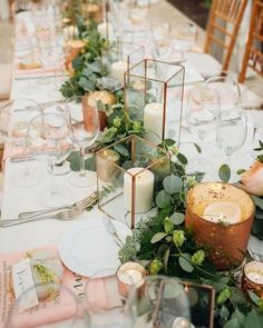 the table is set with candles and greenery