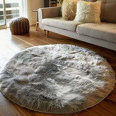 a living room with a couch, chair and rug on the wooden floor next to a window