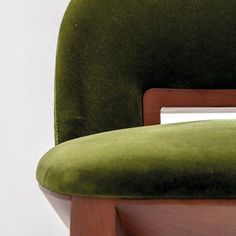 a green chair with wooden frame and seat