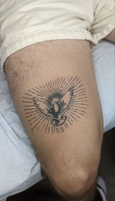 a man with a tattoo on his leg that has a bird and sunburst