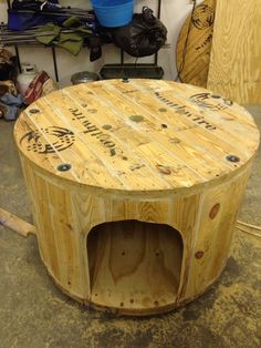 a round wooden table sitting inside of a garage