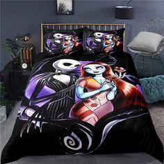 a bed with a black comforter and two halloween themed pillows on top of it