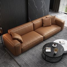 a brown leather couch sitting in a living room next to a table