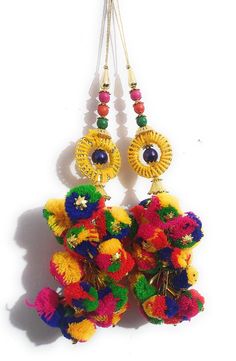 two pairs of earrings hanging from strings with colorful beads and flowers on them, all decorated in different colors