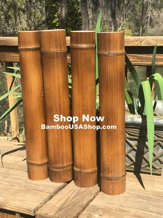 three tall bamboo poles sitting on top of a wooden deck