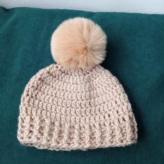 a crocheted hat with a pom - pom on top