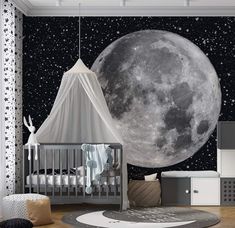 a baby's room with a large moon and stars on the wall behind it