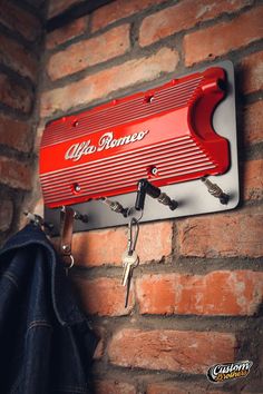 a red wall mounted key holder on a brick wall