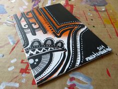 a black and white notebook with an orange design on it