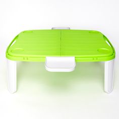 a green table with white legs and a plastic tray underneath it on a white background