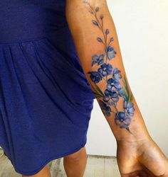 a woman's arm with blue flowers on it