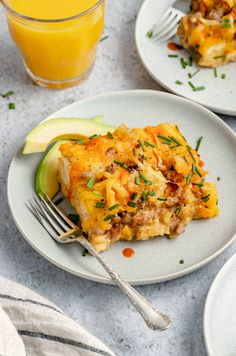 an omelet on a plate with a fork and glass of orange juice next to it