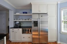 a stainless steel refrigerator freezer sitting inside of a kitchen next to an oven and microwave