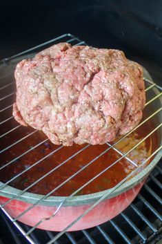 hamburger pattie being cooked on the grill with sauce in pot next to meatloaf