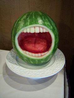 a watermelon with its mouth open on a plate