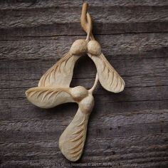 two carved wooden birds sitting on top of a wooden table