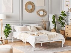 a white bed sitting in a bedroom on top of a hard wood floor