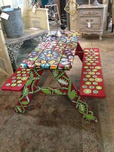 a wooden bench sitting on top of a carpeted floor next to a table with flowers painted on it