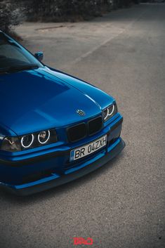 a blue bmw is parked on the street