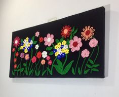 a black wall hanging with colorful flowers on it