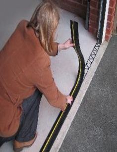 a woman kneeling down on the ground next to a black and yellow striped door mat