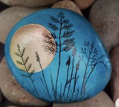 a painted rock sitting on top of some rocks