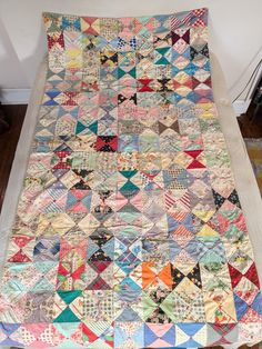 an old quilt is laying on the floor