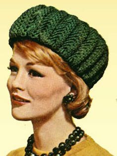 a woman wearing a green knitted hat with pearls on her necklace and earring